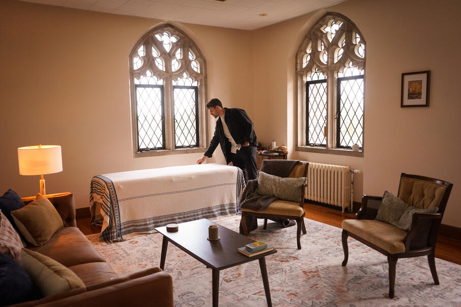 A photo of therapist and educator, Kyle Sullivan, standing in his Rochester, NY based office. There are large windows, multiple seating options, and therapeutic elements to promote trust and ease.